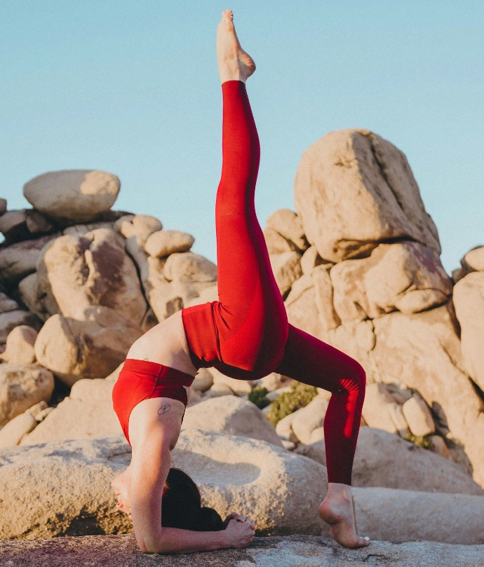 woman doing yoga near rock during daytime